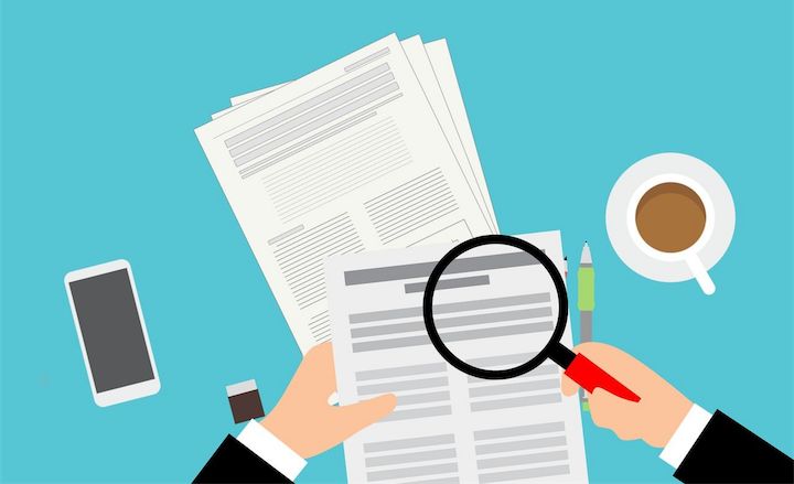 Illustration of hands holding a magnifying glass over scientific research papers.